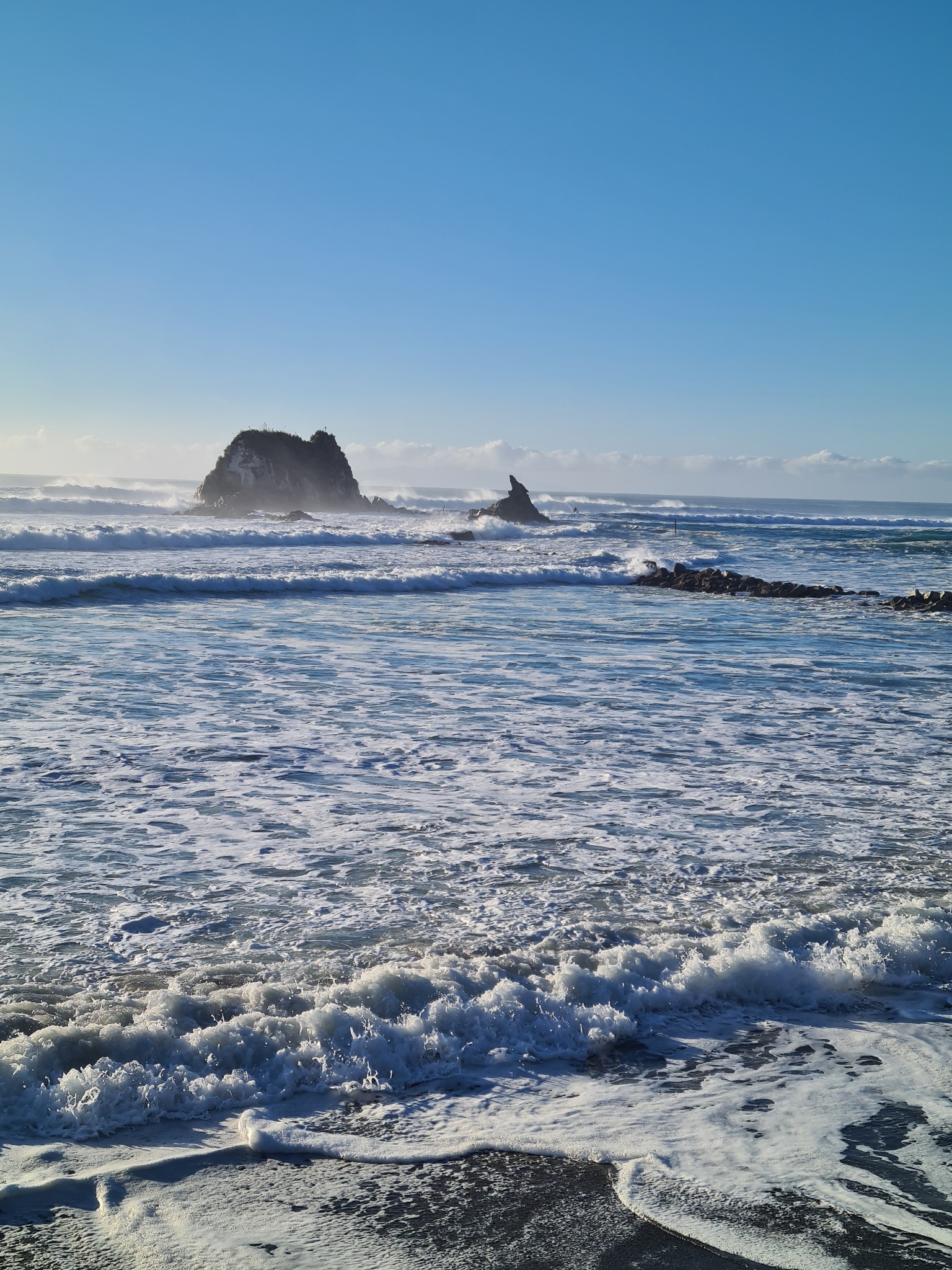 Mangawhai coastline, waves and offshore rock formations viewed from the beach