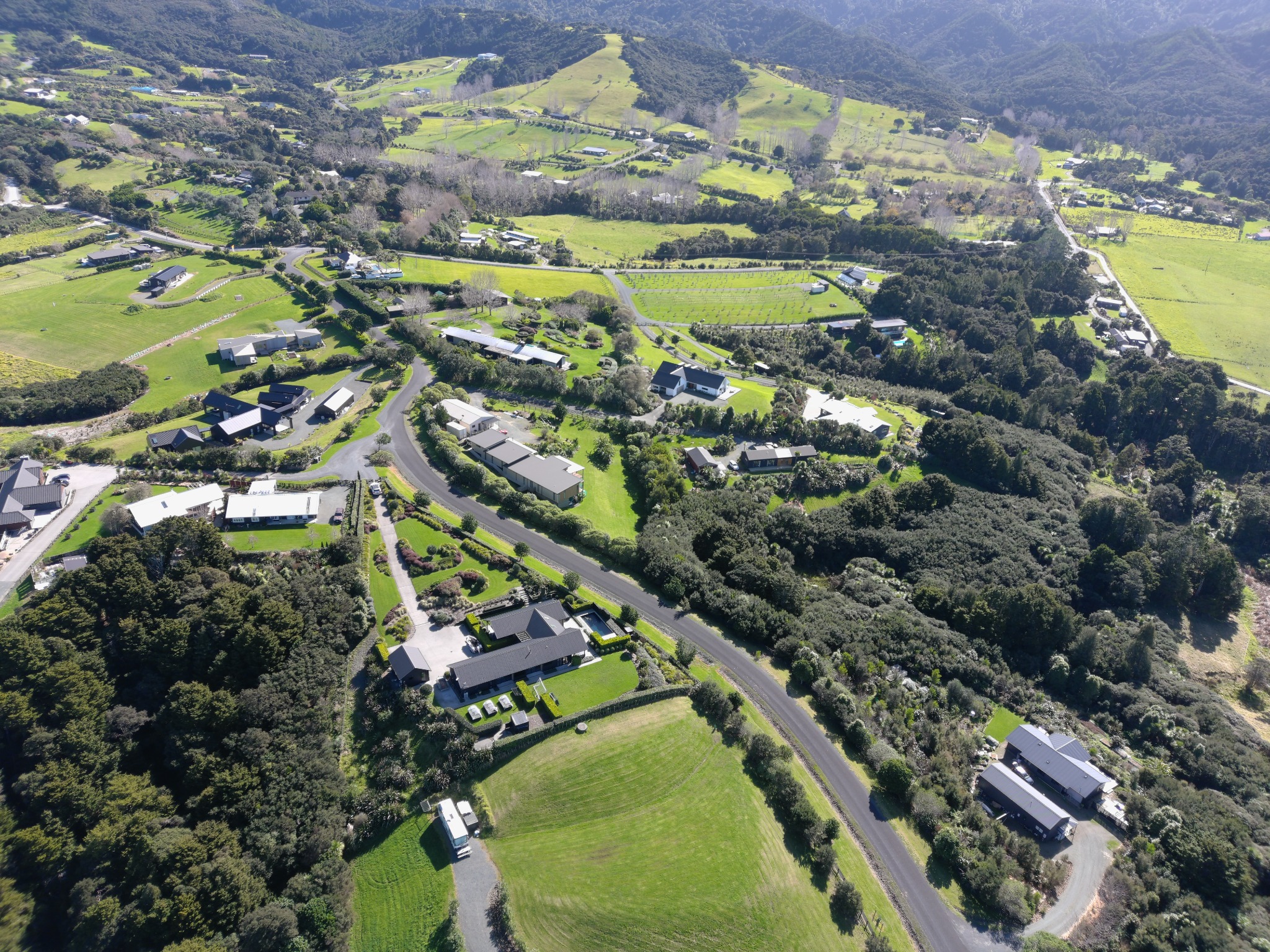 Oblique aerial view across the established homes, landscaping and road at Pigeonberry Lane